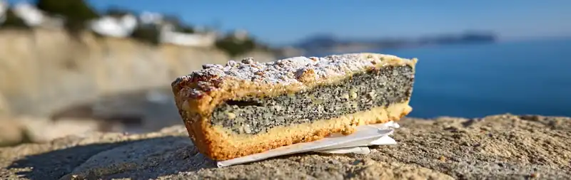 Porción de tarta de semillas de amapola sobre un muro frente al mar en Calpe, Alicante