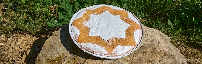 Torta mudéjar tradicional de almendra decorada con azúcar glass en forma de estrella de ocho puntas en Teruel