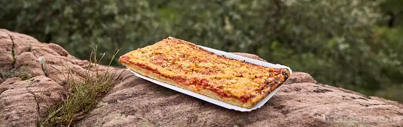 Coca de tomate tradicional con piñones sobre una roca en el entorno natural de Segart, Valencia