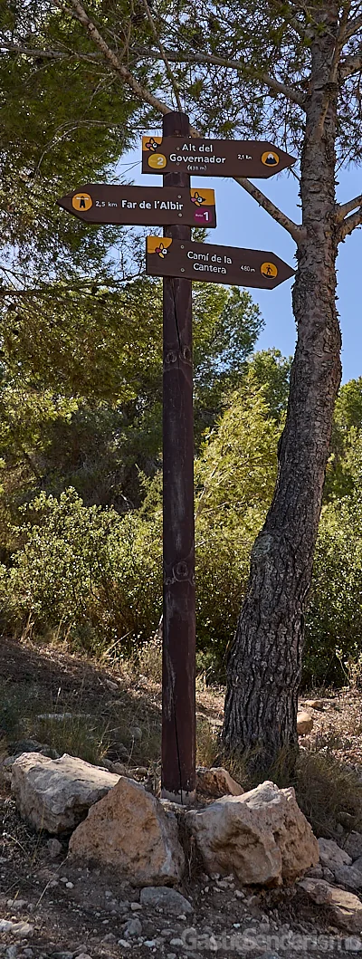 Poste de madera con señales indicadoras de rutas hacia el Faro de l'Albir, Alt del Governador y Camí de la Cantera en el Parque Natural de la Serra Gelada