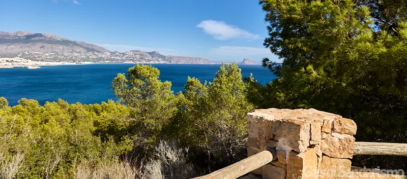 Vistas panorámicas de la bahía de Altea y el Peñón de Ifach desde un mirador de piedra en la ruta del Camino Viejo del Faro del Albir, Serra Gelada.
