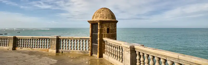 Garita de piedra y balaustrada en el Paseo de Santa Bárbara sobre el mar en Cádiz